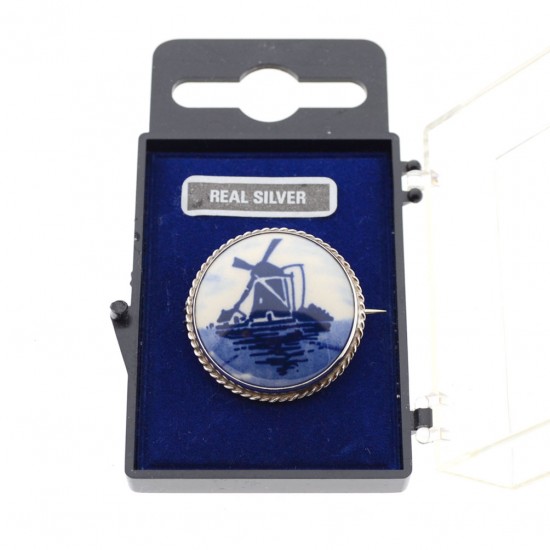 Silberbrosche mit Delfter Blaustein mit Mühle in Landschaft. Der Schmuck ist in einer transparenten Box verpackt.
