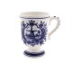 Delft blue mug on foot, classically decorated with a windmill in a typical Dutch landscape with the text Holland. The back of the coffee mug is decorated with Delft blue flowers.