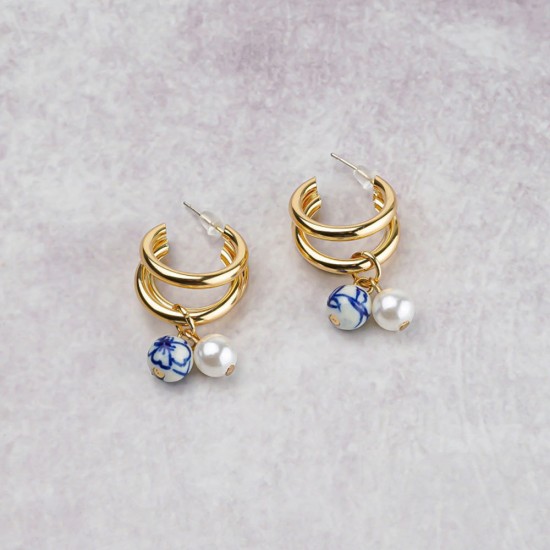 Wunderschöne goldfarbene Ohrringe mit einem Anhänger mit einer Perle in Perleffekt und einer handbemalten Delfter blauen Keramikperle.