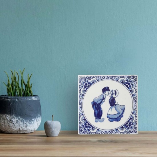 Tile with a Delft blue decoration of a kissing couple bordered with Delft flower decoration. A beautiful sturdy tile made of Delft blue earthenware. 