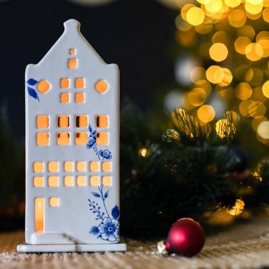 Ceramic tealight holder of a Dutch canal house with spout facade with elegant Delft blue decoration. The tea lights are easy to replace because the house is on a separate platform.