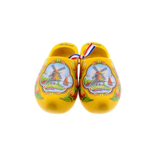 A pair of yellow wooden shoes in color decorated with a windmill in a typical Dutch landscape and tulips with the text Holland on the edge