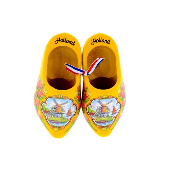 A pair of yellow wooden shoes in color decorated with a windmill in a typical Dutch landscape and tulips with the text Holland on the edge