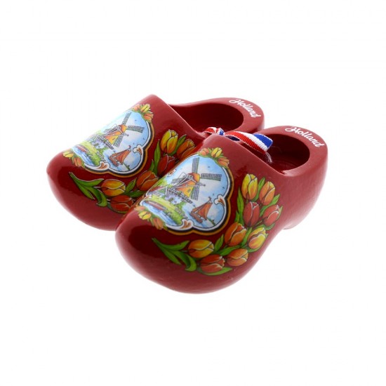 Ein Paar rote Holzschuhe, in Farbe verziert mit einer Windmühle in einer typisch holländischen Landschaft und Tulpen mit dem Text Holland am Rand