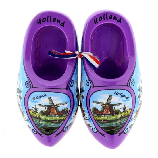 Ein Paar lila Holzschuhe, in Farbe verziert mit einer Windmühle in einer typisch holländischen Landschaft und Tulpen mit dem Text Holland am Rand